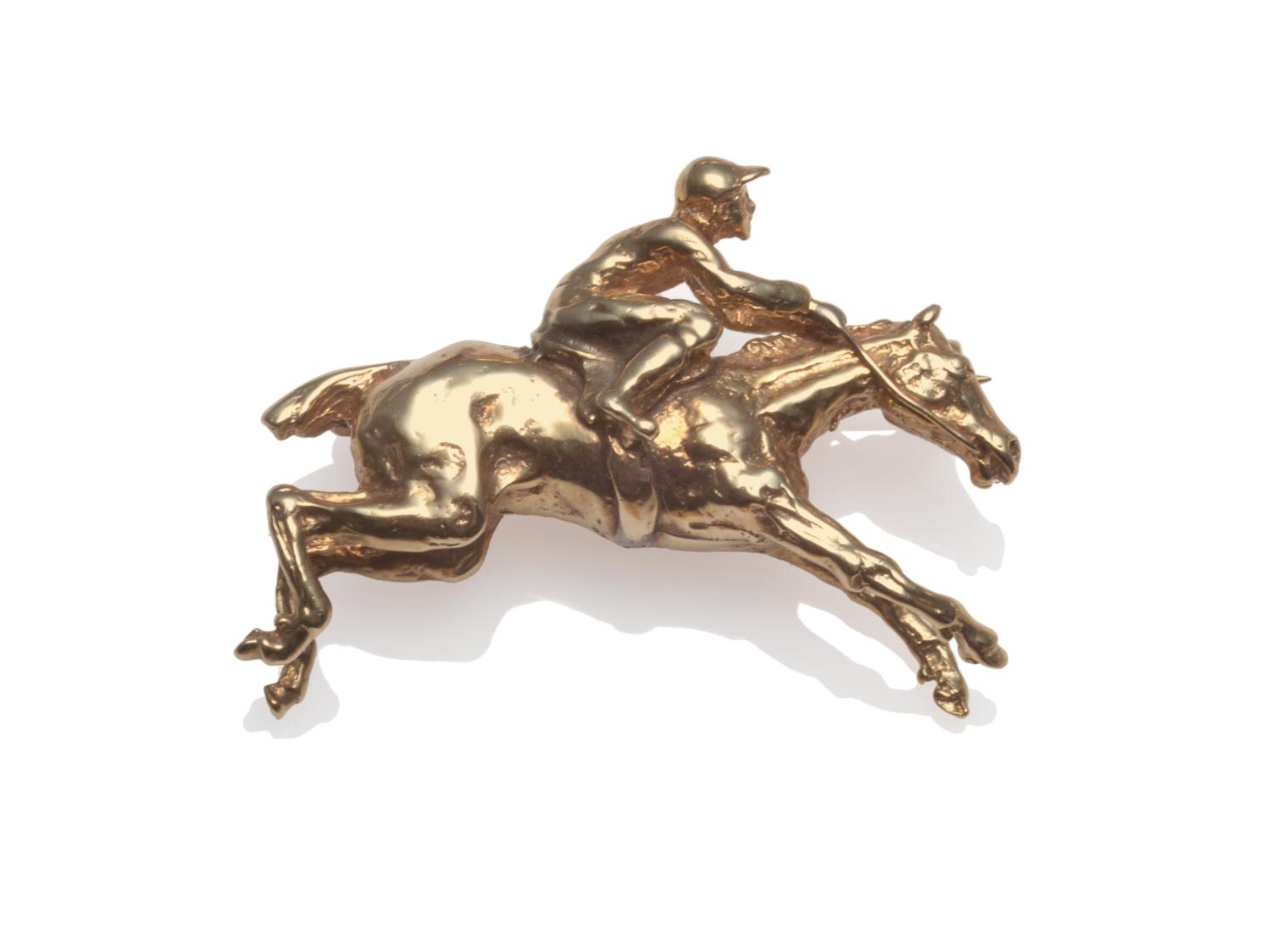 Lot 2071 - A 9 Carat Gold Horse and Jockey Brooch, realistically modelled as a galloping horse with jockey...