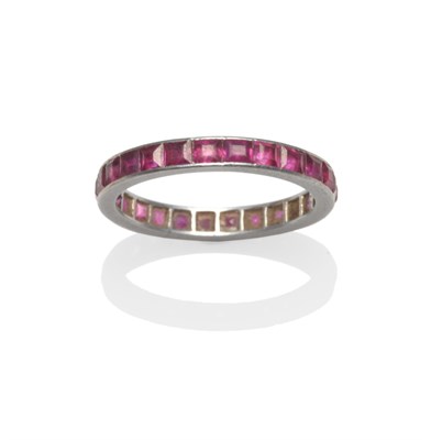 Lot 2141 - A Ruby Eternity Ring, the step cut rubies in a white flat sided shank, finger size L1/2