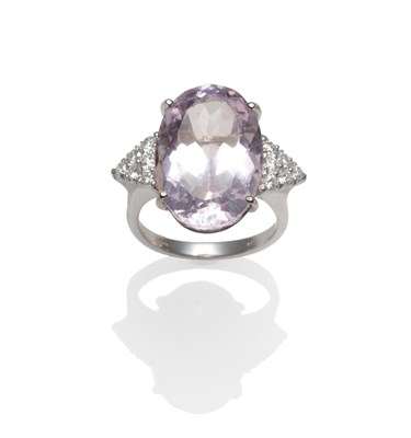 Lot 2150 - An 18 Carat White Gold Kunzite and Diamond Ring, the oval cut kunzite between triangular...