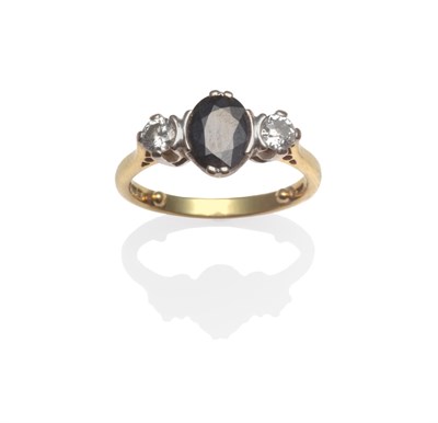 Lot 2158 - An 18 Carat Gold Sapphire and Diamond Three Stone Ring, the oval cut sapphire flanked by a...