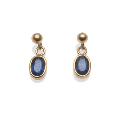 Lot 2168 - A Pair of Sapphire Drop Earrings, a ball stud suspends an oval cut sapphire in a yellow collet...