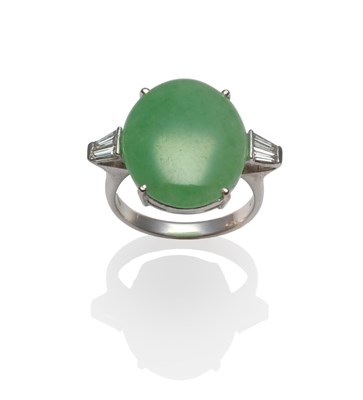 Lot 2199 - An 18 Carat White Gold Jade and Diamond Ring, the cabochon jade with a pair of tapered baguette cut