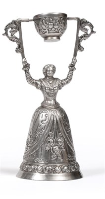 Lot 2359 - A Continental White Metal Wager Cup/Bell, typically modelled as a woman in a long dress with a...