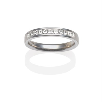 Lot 2002 - An 18 Carat White Gold Half Hoop Ring, princess cut diamonds channel set, on a plain polished...