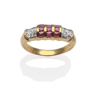 Lot 2023 - A Ruby and Diamond Ring, set with calibré cut rubies in a three row yellow channel setting,...