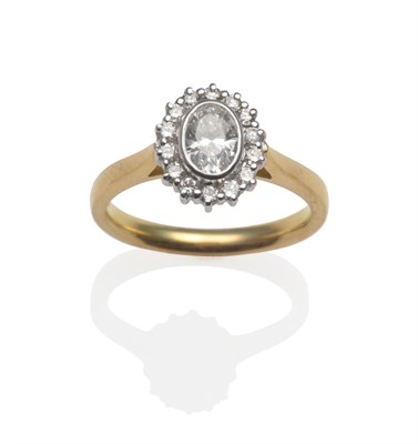 Lot 2036 - An 18 Carat Gold Oval Diamond Cluster Ring, an oval cut diamond in white rubbed over setting within