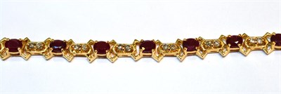 Lot 2045 - A Ruby and Diamond Bracelet, with oval cut rubies spaced by pairs of round brilliant cut...