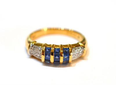 Lot 2058 - A Sapphire and Diamond Ring, set with calibré cut sapphires in a three row yellow channel setting