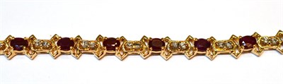 Lot 2059 - A Ruby and Diamond Bracelet, with oval cut rubies spaced by pairs of round brilliant cut...