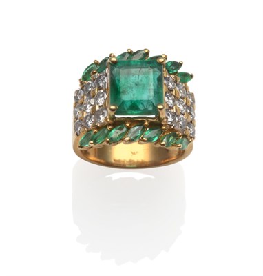 Lot 2065 - An Emerald and Diamond Cluster Ring, an emerald-cut emerald in yellow claw setting, flanked by...