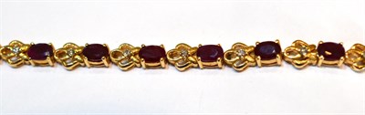 Lot 2078 - A Ruby Bracelet, oval cut rubies alternating with open work links each set with a round diamond...