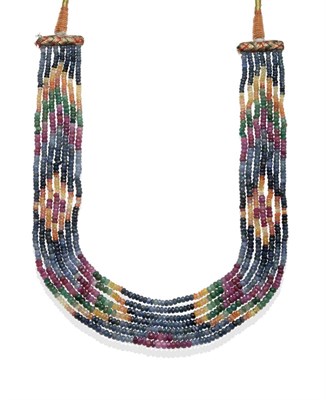 Lot 2083 - A Multi-Coloured Gemstone Seven String Necklace on Fabric Woven Mount, with graduating faceted...