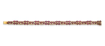 Lot 2103 - A Ruby and Diamond Bracelet, the three row bracelet set with pairs of pear cut rubies...