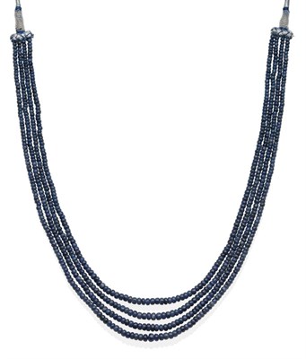 Lot 2110 - A Sapphire Four String Necklace on Fabric Woven Mount, with graduating tumbled sapphire beads...