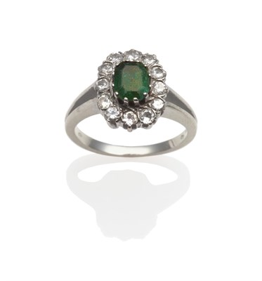 Lot 2114 - An Emerald and Diamond Cluster Ring, the emerald-cut emerald within a border of round brilliant cut