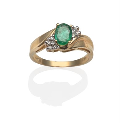 Lot 2129 - An Emerald and Diamond Ring, crossover style with an oval cut emerald in yellow claw setting,...