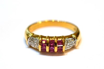 Lot 2131 - A Ruby and Diamond Ring, set with calibré cut rubies in a three row yellow channel setting,...