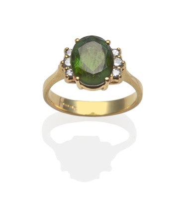 Lot 2143 - A Green Tourmaline and Diamond Ring, an oval mixed cut green tourmaline flanked by round...