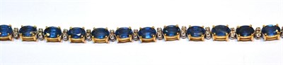 Lot 2144 - A Sapphire and Diamond Bracelet, the oval sapphires spaced by pairs of round cut diamonds, in white