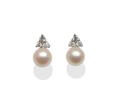 Lot 2148 - A Pair of Cultured Pearl and Diamond Stud Earrings, each with three brilliant cut diamonds in white