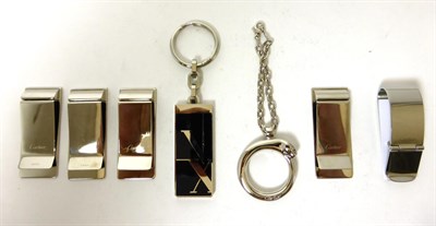 Lot 2225 - Cartier New Old Stock Comprising: Roman Numeral Money Clip (x4); Santos de Cartier Black Money...