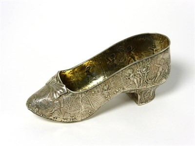 Lot 2239 - A Dutch Silver Model of a Clog, the sides chased with playful putti in a landscape, 17cm long, 4oz