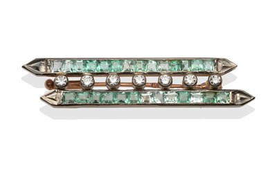 Lot 2002 - An Art Deco Emerald and Diamond Brooch, formed of two white parallel bars channel set with calibré