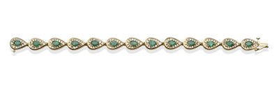 Lot 2017 - An Emerald and Diamond Bracelet, pear shaped links each with a pear cut emerald in yellow claw...