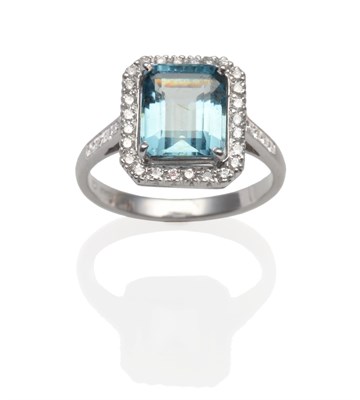 Lot 2022 - An 18 Carat White Gold Aquamarine and Diamond Ring, an emerald-cut aquamarine within a border...