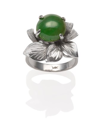 Lot 2034 - A Jade Ring, a round cabochon jade in a white four claw setting within a textured leaf spray,...