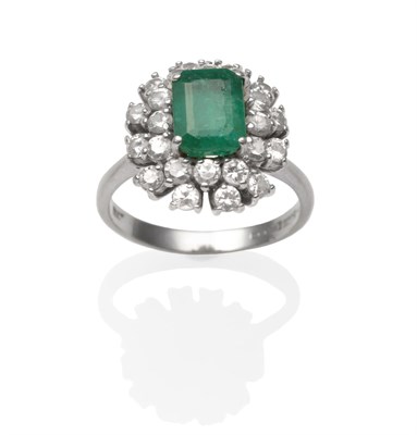 Lot 2041 - An 18 Carat White Gold Emerald and Diamond Cluster Ring, an emerald-cut emerald within a two...