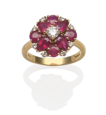 Lot 2043 - An 18 Carat Gold Ruby and Diamond Cluster Ring, a round brilliant cut diamond between pear cut...