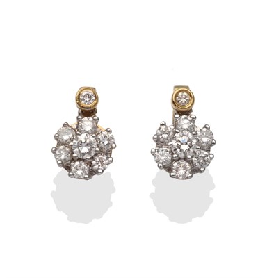 Lot 2062 - A Pair of Diamond Cluster Earrings, a round brilliant cut diamond in yellow rubbed over setting...