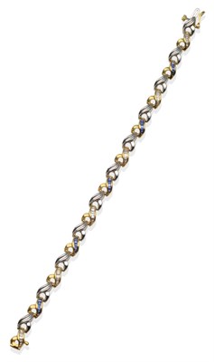 Lot 2083 - A Diamond and Sapphire Bracelet, yellow scroll links channel set with alternating baguette cut...