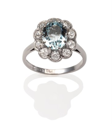 Lot 2088 - An Aquamarine and Diamond Cluster Ring, an oval cut aquamarine in a white claw setting within a...