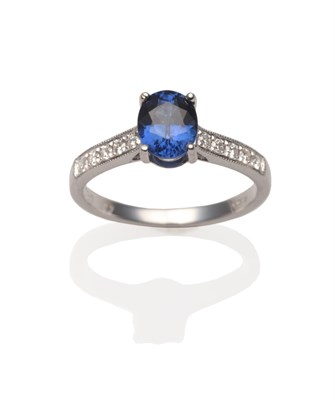 Lot 2090 - An 18 Carat White Gold Sapphire and Diamond Ring, an oval cut sapphire in a white four claw...