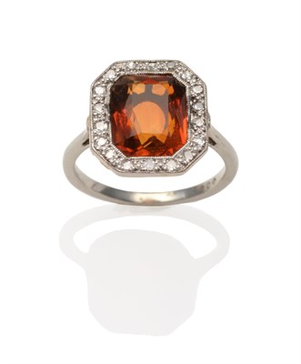 Lot 2092 - A Citrine and Diamond Ring, an octagonal cut citrine in a white millegrain setting within a...