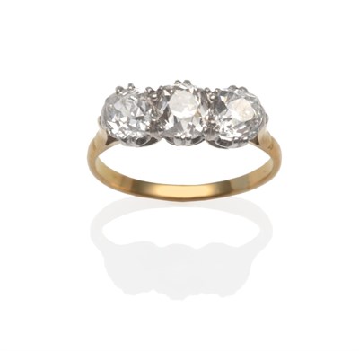 Lot 2108 - A Diamond Three Stone Ring, the old cut diamonds in white double claw settings, on a yellow...