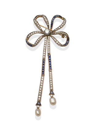 Lot 2132 - A Diamond and Sapphire Bow Brooch, with a central round brilliant cut diamond, and calibré cut...