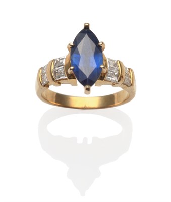 Lot 2148 - A Sapphire and Diamond Ring, a marquise cut sapphire in a yellow claw setting with baguette cut...