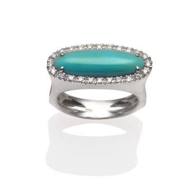 Lot 2165 - A Turquoise and Diamond Ring, a long oval turquoise cabochon within a border of round brilliant cut