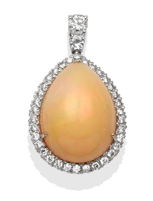 Lot 2227 - An 18 Carat White Gold Opal and Diamond Pendant, a pear shaped cabochon opal within a border of...