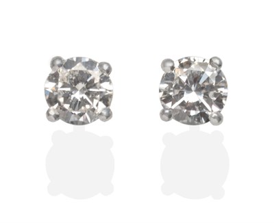 Lot 2001 - A Pair of Diamond Solitaire Earrings, a round brilliant cut diamond in a white four claw...