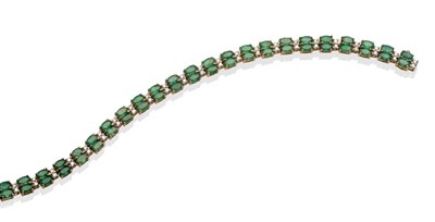 Lot 2010 - A 9 Carat Gold Emerald and Diamond Line Bracelet, pairs of oval cut emeralds spaced by pairs of...