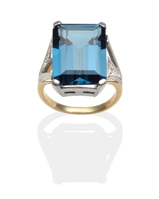 Lot 2033 - A Blue Topaz and Diamond Ring, an emerald-cut blue topaz in a white claw setting, to pierced...