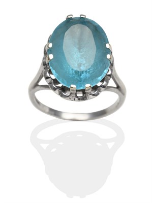 Lot 2035 - A 9 Carat White Gold Blue Topaz Ring, an oval cut blue topaz in a white claw setting and with a...