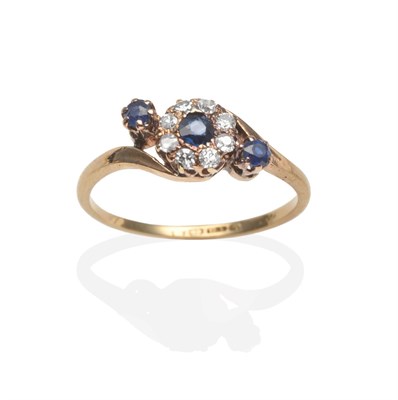 Lot 2041 - An 18 Carat Gold Diamond and Sapphire Cluster Ring, a round cut sapphire within a border of old cut