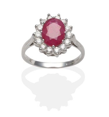 Lot 2042 - An 18 Carat White Gold Ruby and Diamond Cluster Ring, an oval cut ruby within a border of round...