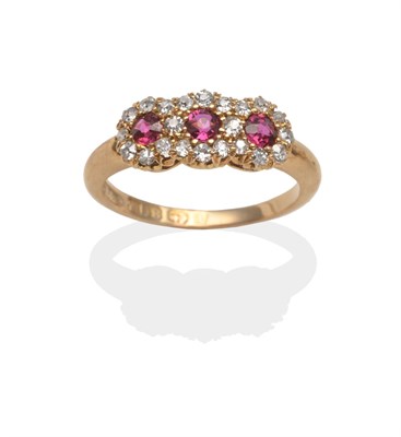 Lot 2055 - An 18 Carat Gold Ruby and Diamond Triple Cluster Ring, three round cut rubies within a cluster...