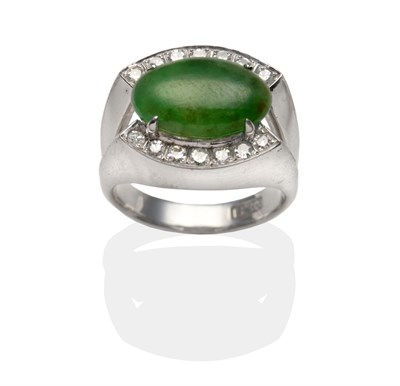 Lot 2097 - A Jade and Diamond Ring, an oval cabochon jade in a white claw setting between to rows of pavé set